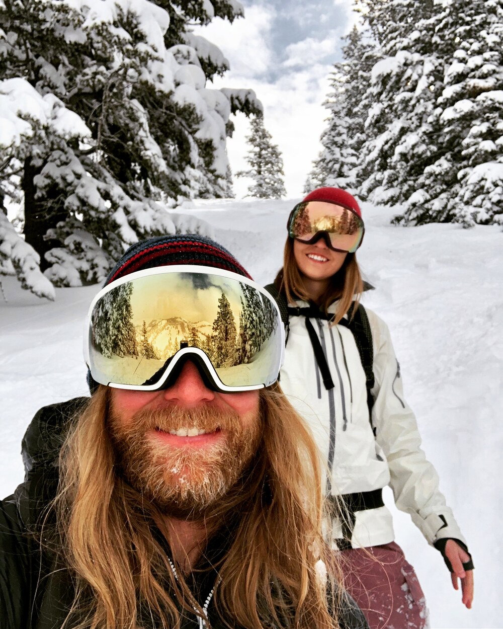 Bass and Madie in goggles on a deep snow day in the trees